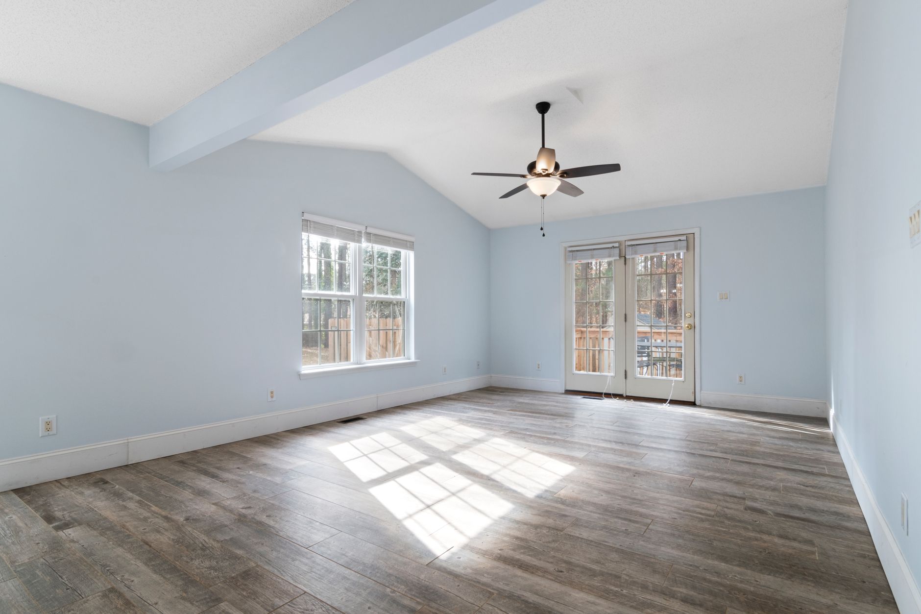 Empty living room with bay windows and hardwood floors