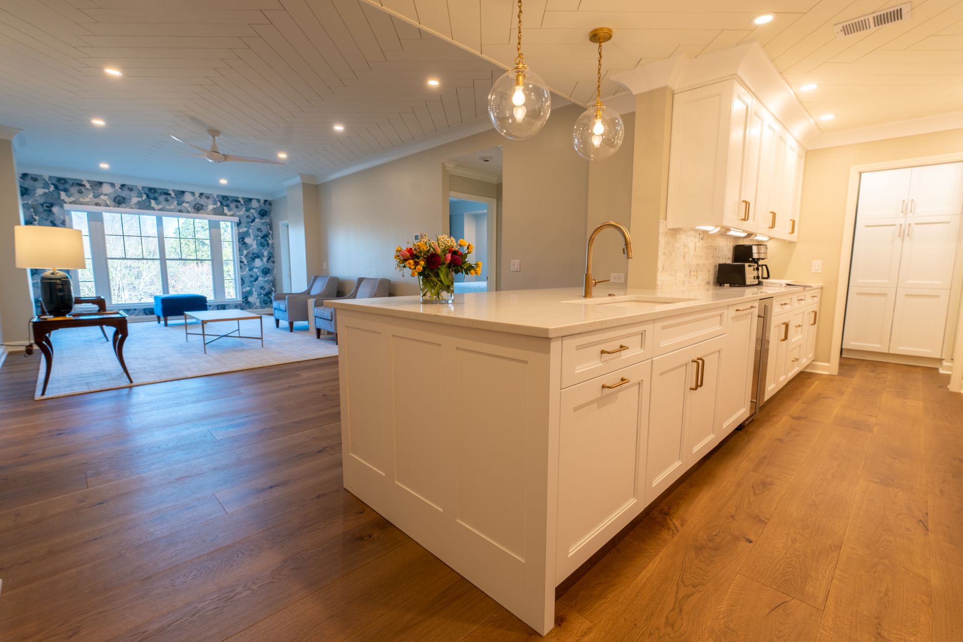 Open plan kitchen with an island, pendant lights and wood floors