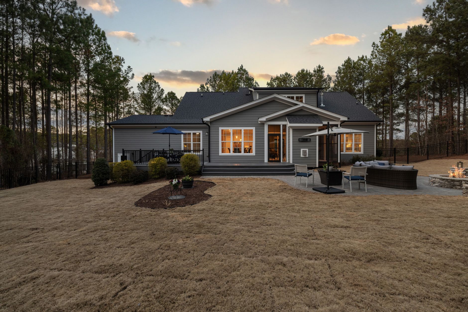 Single story home with a covered patio and fire pit at sunset