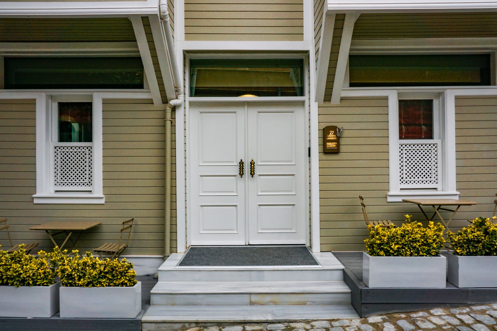 White double front door of a craftsman home with planters